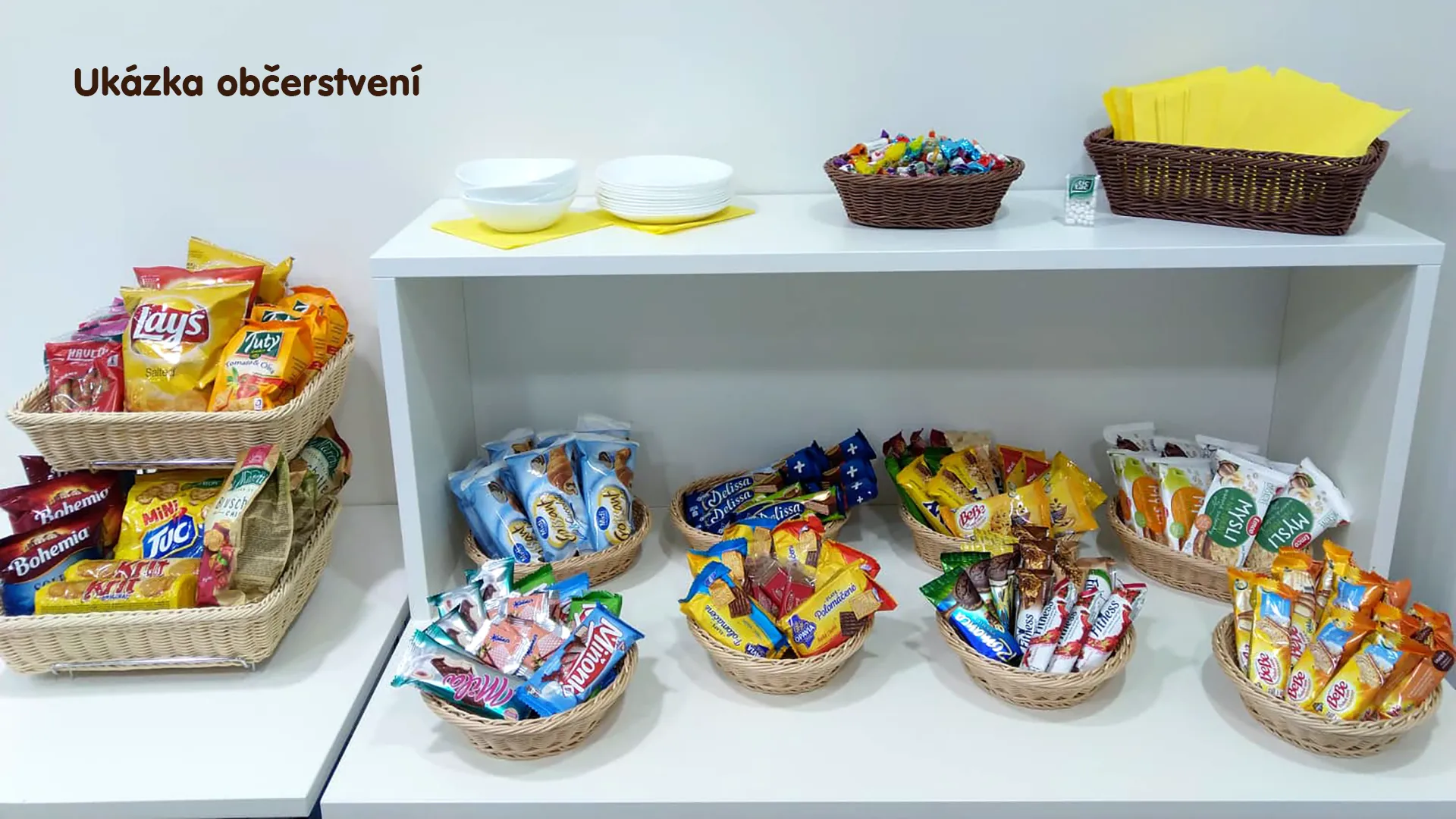 Wicker baskets filled with packaged savory snacks, sweet biscuits, and snack bars.